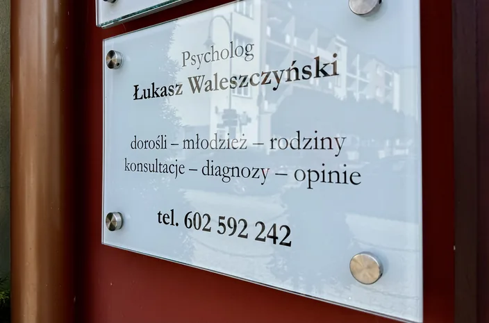 Szklana tabliczka przy wejściu z napisem: Psycholog Łukasz Waleszczyński